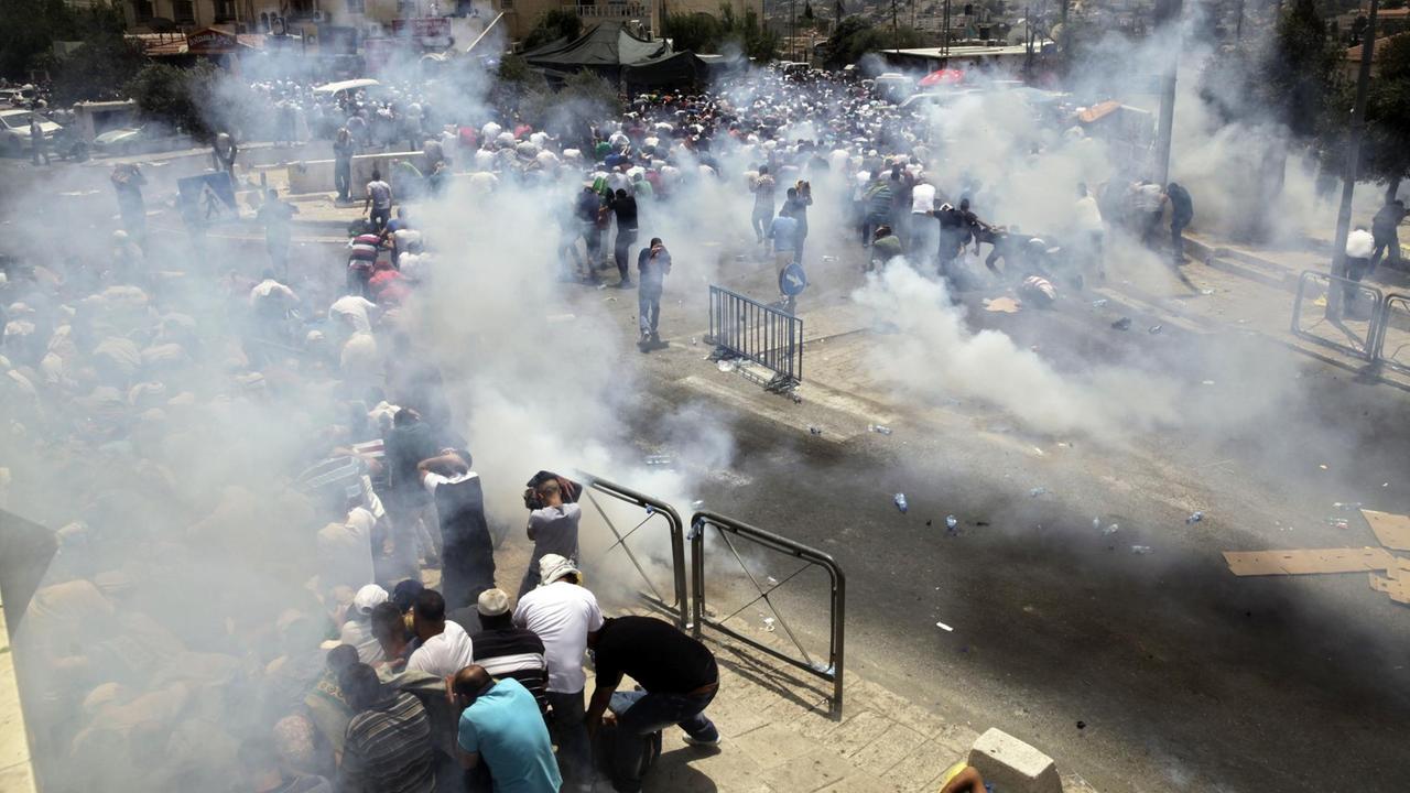 Israelische Soldaten schießen am 21.07.2017 in Jerusalem mit Tränengas in Richtung palästinensischer Demonstranten.