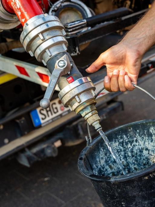 Einsatzkräfte der Freiwilligen Feuerwehr Lauenau zapfen Löschwasser aus dem Tank eines ihrer Einsatzfahrzeuge. In der Gemeinde im Landkreis Schaumburg ist die Wasserversorgung nach warmen Tagen und während der Corona-Pandemie zusammengebrochen. Die Abnahmemenge im privaten Bereich sei drastisch gestiegen.