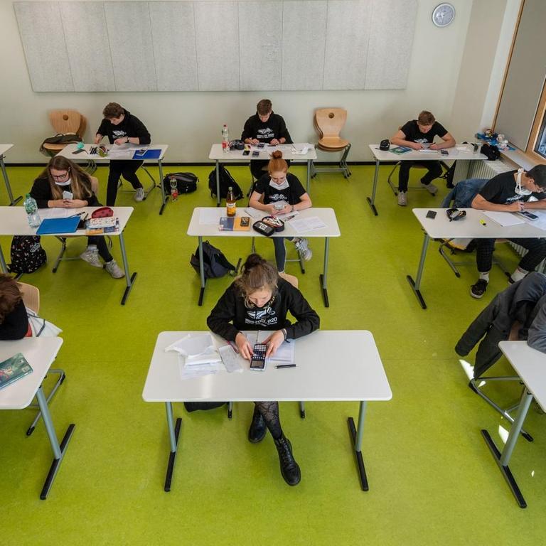 Abiturienten am Gymnasium Dresden Klotzsche sitzen in einem Klassenzimmer für Prüfungsvorbereitungen.