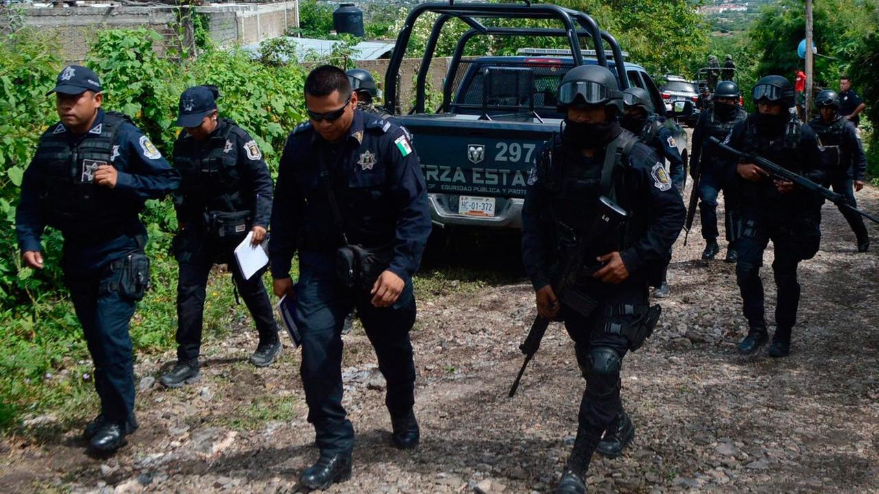 Mexikanische Polizisten sind auf dem Weg, dass in Iguala gefundene Massengrab zu untersuchen.
