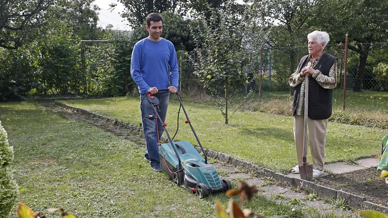 Student Hossein Pazouki hilft in Berghausen/Pfinztal  einer Rentnerin beim  Rasenmähen.