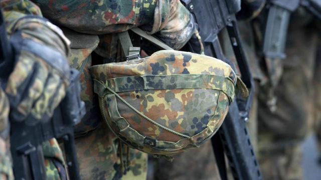 Zu sehen sind Soldaten in Ausrüstung mit Helm und Gewehr.