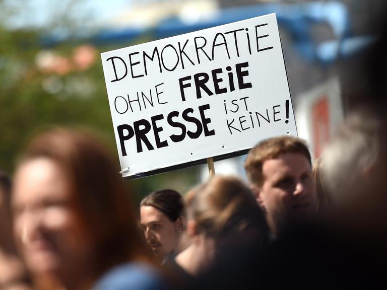 Eine Teilnehmerin einer Demonstration von Unterstützern des Internetportals Netzpolitik.org hält am 1. August 2015 in Berlin bei der Demonstration ein Schild "Demokratie ohne freie Presse ist keine!" in der Hand.