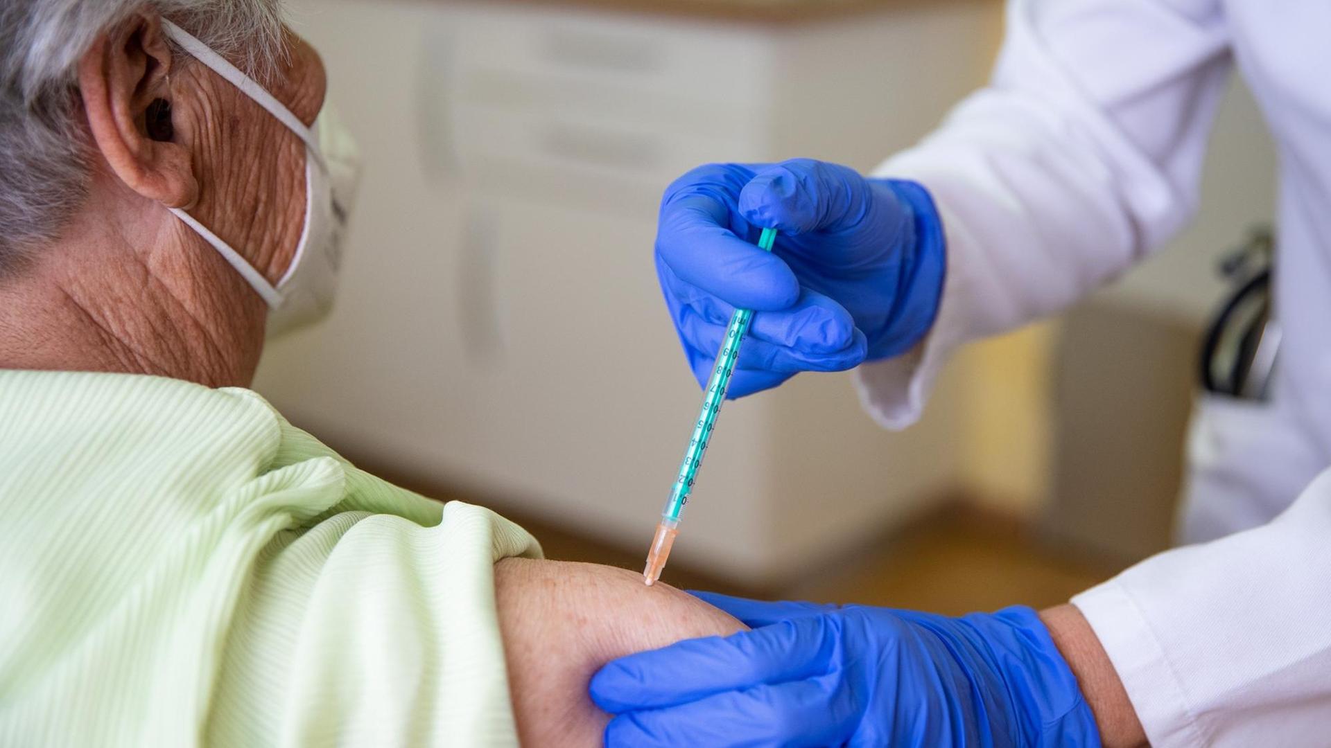 Nicola Buhlinger-Göpfarth (r), Fachärztin für Allgemeinmedizin, impft in ihrer Praxis eine Patientin gegen das Coronavirus.
