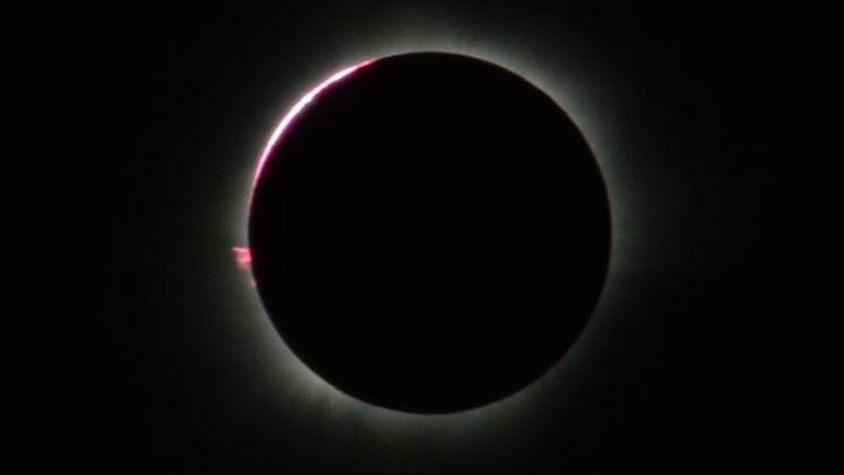 Das Perlschnurphänomen: Die Sonne leuchtet durch Täler am Mondrand hindurch.