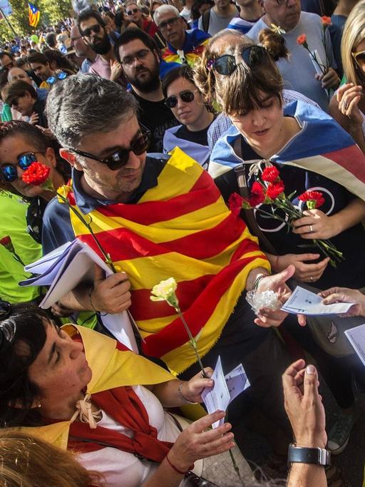 Ein Mann verteilt am 23.09.2017 auf einem Protestmarsch in Barcelona Flugblätter zur Unterstützung des Unabhängigkeitsreferendums für Katalonien.