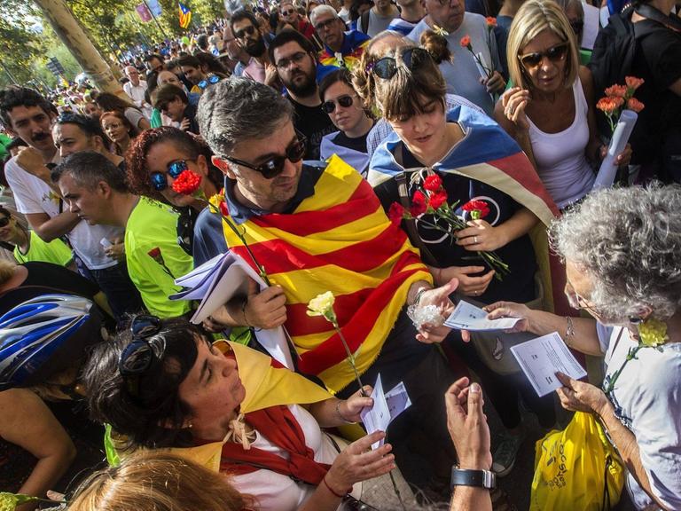 Ein Mann verteilt am 23.09.2017 auf einem Protestmarsch in Barcelona Flugblätter zur Unterstützung des Unabhängigkeitsreferendums für Katalonien.