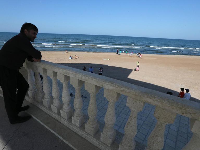 Ein Mann an der Küste von Derbent schaut aufs Meer.