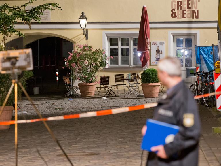 Ein Polizist arbeitet in Ansbach am Tatort.