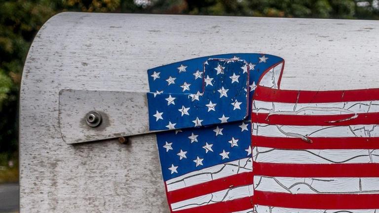 Ein typischer Briefkasten mit einer wehenden US-Flagge steht an einer Straße unweit von Boston, Massachusetts. Ein typischer Briefkasten mit einer wehenden US-Flagge steht an einer Straße unweit von Boston, Massachusetts.