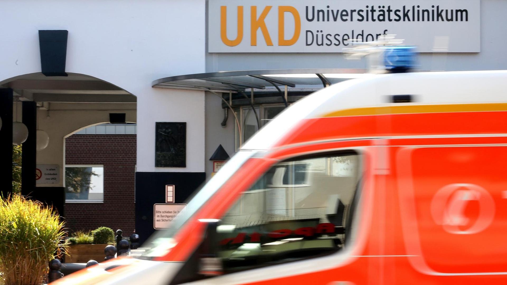 Am Haupteingang zum Universitätsklinikum Düsseldorf fährt ein Krankenwagen vorbei