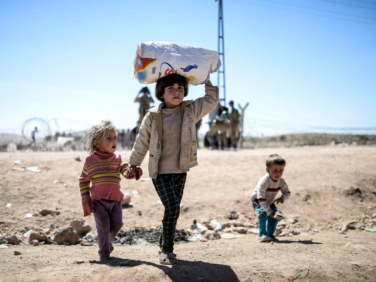 Syrische Kurden überqueren am 20. September 2014 die Grenze nahe der Stadt Suruc die Grenze von Syrien zur Türkei.