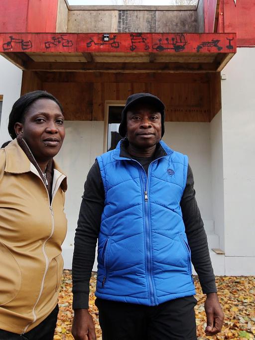 Der Sprecher der Lampedusa-Gruppe, Asuquo Udo, und Esther Olaide Olokodena, Mitglied der Gruppe, vor dem Kunstprojekt und Flüchtlingsquartier "Ecofavela" auf Kampnagel in Hamburg.