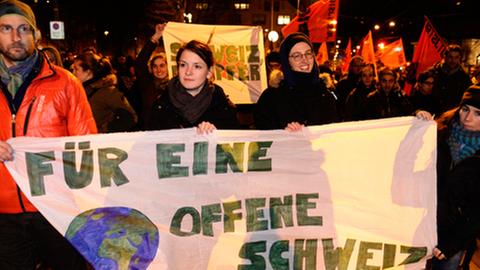 Schweizer tragen ein Demonstrationsplakat mit der Aufschrift: Für eine offene Schweiz
