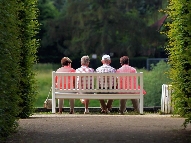 Mehrere ältere Personen sitzen am 31.05.2016 auf einer Parkbank im Schlosspark Pillnitz (Sachsen). Foto: Arno Burgi