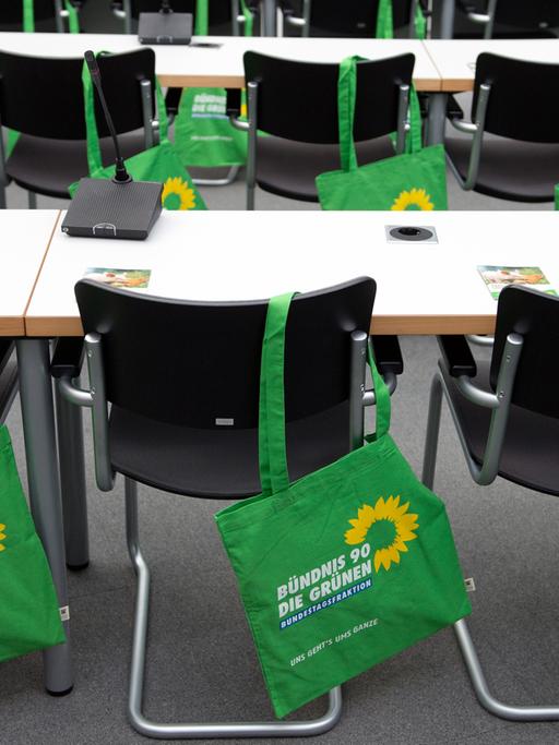 Stoffbeutel mit dem Grünen-Logo hängen im vor Beginn einer Fraktionssitzung 2012 im Bundestag über den Stuhllehnen.