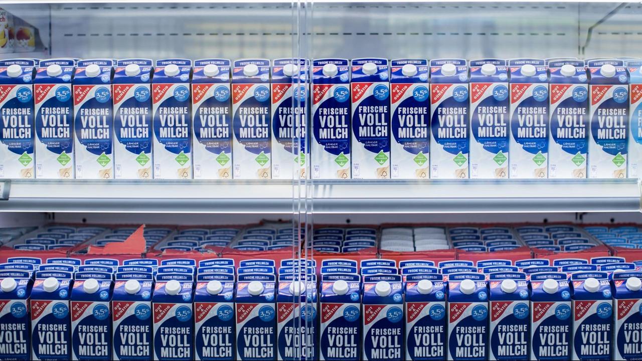 Viele Milch-Tetra-Packs im Kühlregal eines Supermarkts.