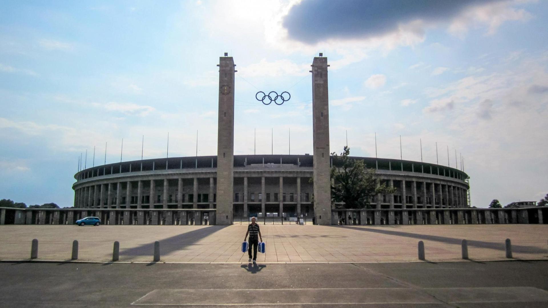 Haupteingang des Olympiastadions Berlin, darüber blauer Himmel und Wolken.