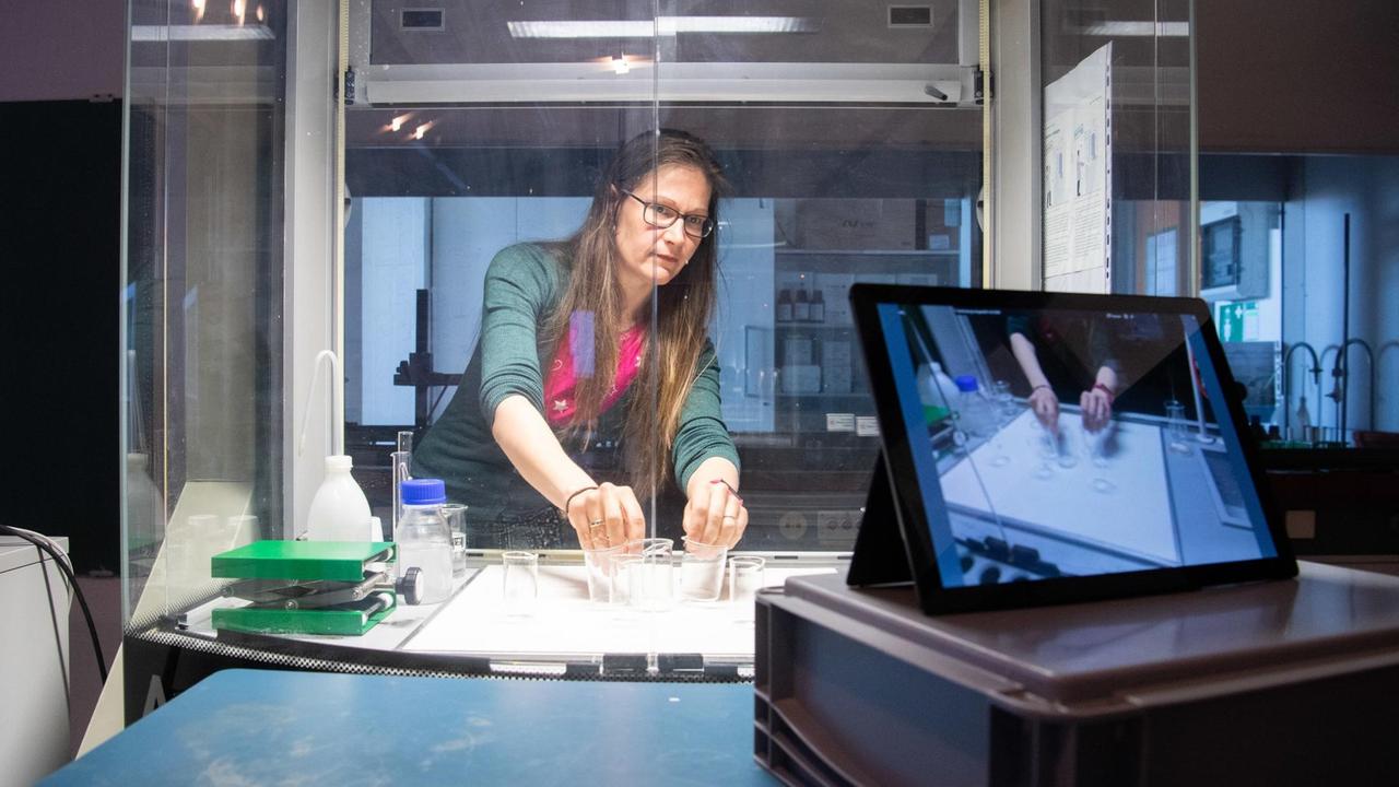Eine wissenschaftliche Mitarbeiterin am Institut für Chemie einer deutschen Universität hält im April 2020 vor einem Tablet-Computer mit Kamera eine digitale Vorlesung "Physikalische Chemie I". 