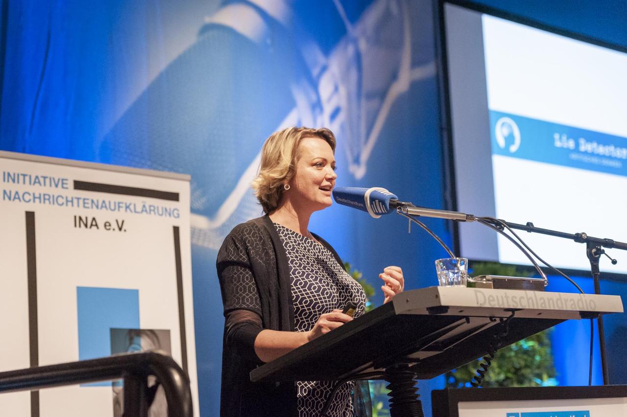 Eine Frau spricht auf einer Bühne in ein Mikrofon. Es ist Juliane von Reppert-Bismarck von der Organisation "Lie Detectors".