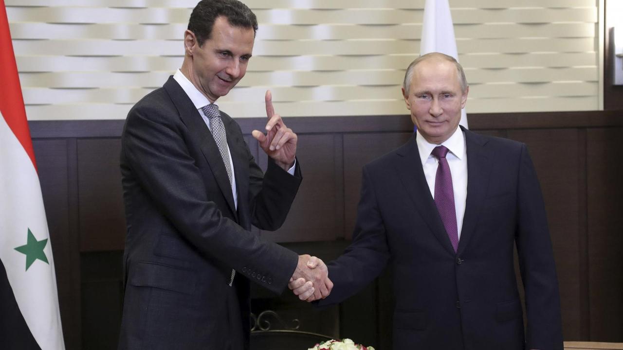 Wladimir Putin (r) und Syriens Präsident Baschar al-Assad geben sich die Hand. 