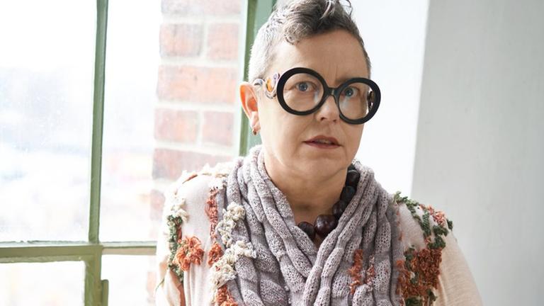 Porträt der Modedesignerin Martina Glomb. Sie trägt eine modische Brille und einen Kurzhaarschnitt.