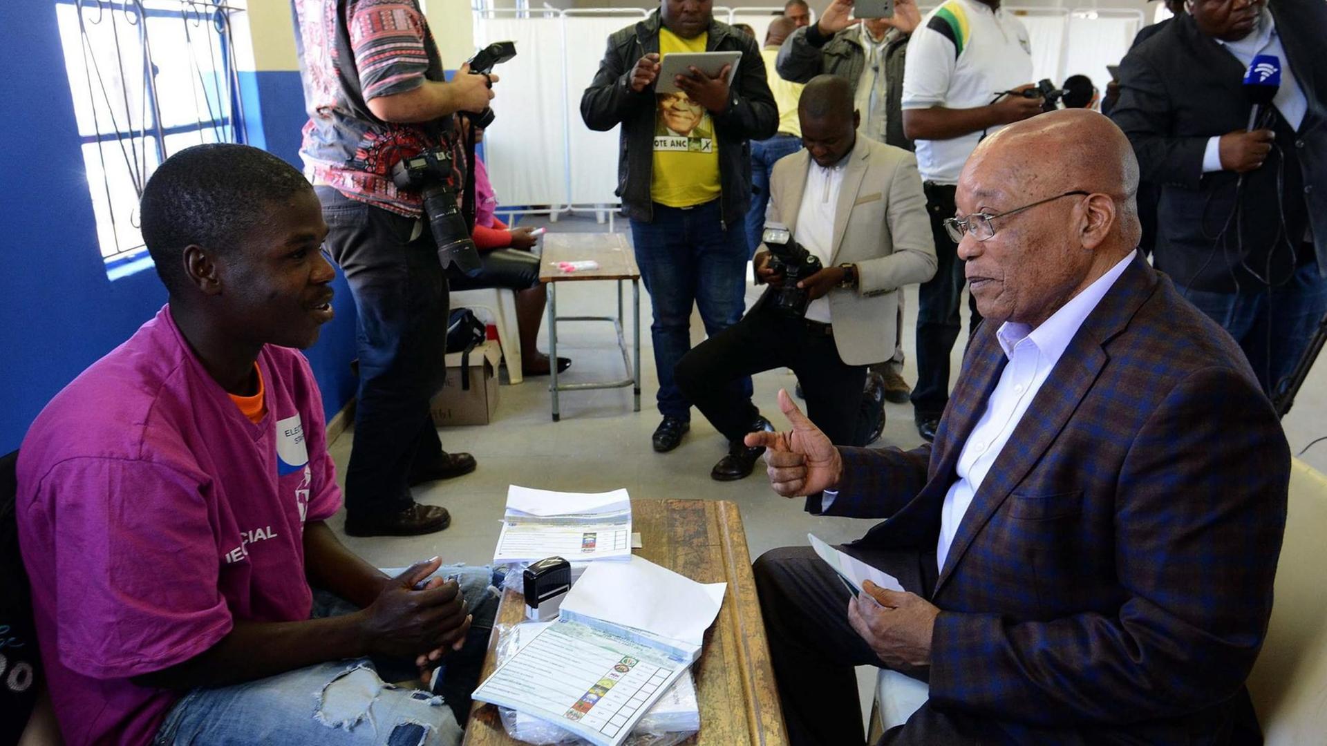 Präsident Jacob Zuma spricht mit einem Helfer in einem Wahllokal in Nkandla.