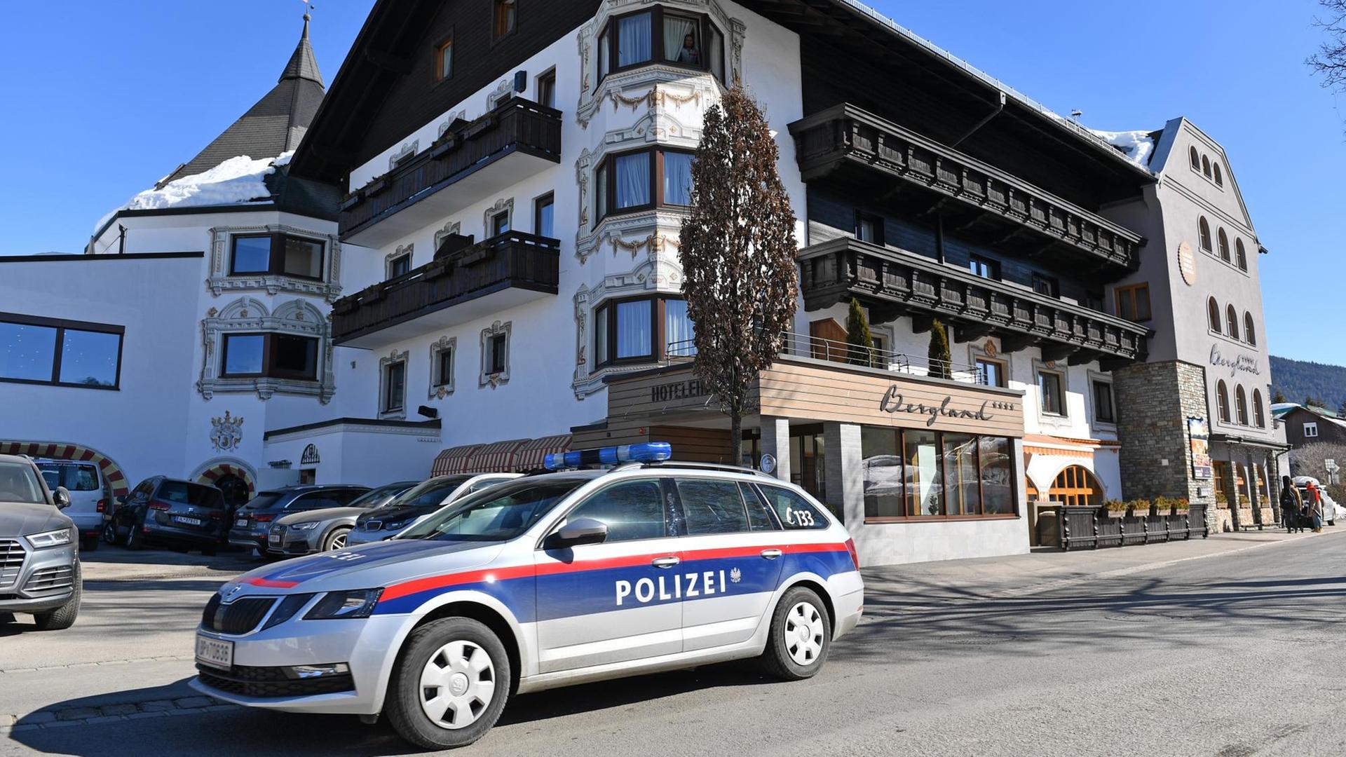Ein Polizei-Auto fährt an einem Ski-Hotel vorbei