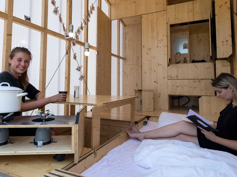 Architekturstudentinnen Sarah Ullmayer (r) und Sophie Kany sitzen am 20.07.2017 im Bauhaus Campus in Berlin in dem von ihnen entworfenen Tiny Haus (Minihaus) "35KubikHeimat".