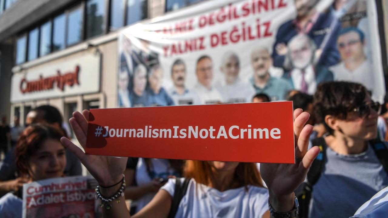 Vor der Zentrale der "Cumhuriyet" in Istanbul protestieren Menschen gegen den Prozess gegen Mitarbeiter der Zeitung.

