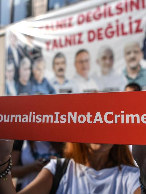 Vor der Zentrale der "Cumhuriyet" in Istanbul protestieren Menschen gegen den Prozess gegen Mitarbeiter der Zeitung.
