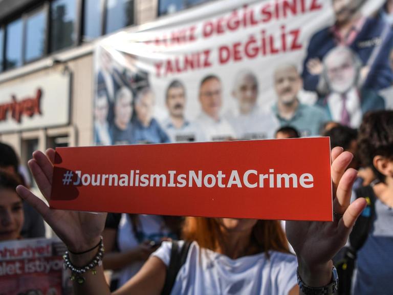 Vor der Zentrale der "Cumhuriyet" in Istanbul protestieren Menschen gegen den Prozess gegen Mitarbeiter der Zeitung.