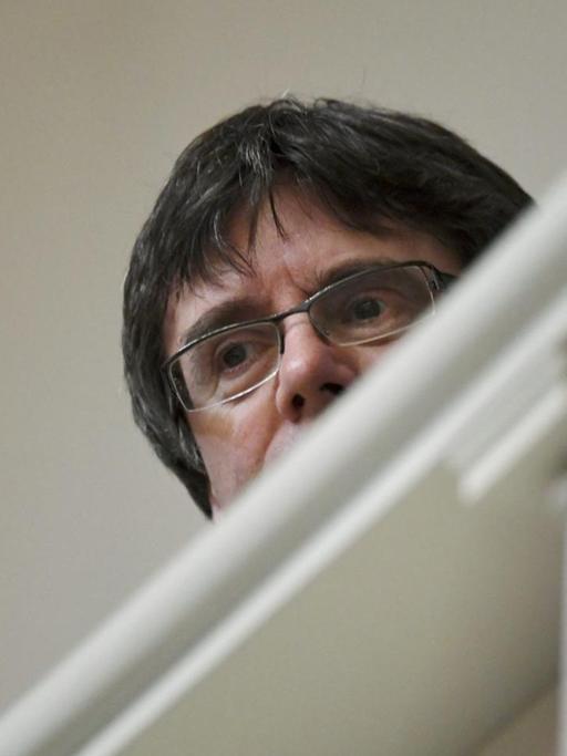 Carles Puigdemont - untersichtig fotografiert. Im Vordergrund ein Geländer.