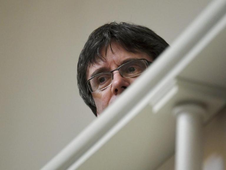 Carles Puigdemont - untersichtig fotografiert. Im Vordergrund ein Geländer.