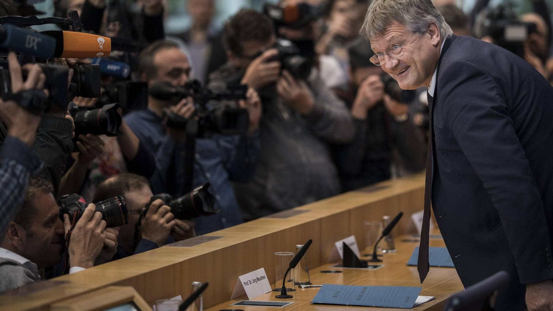 Der AfD-Parteichef Jörg Meuthen nimmt in der Bundespressekonferenz Platz, vor ihm eine Reihe Journalisten mit Kameras.