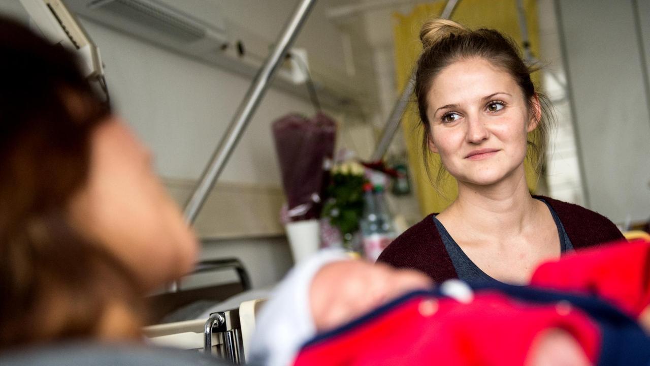 Babylotsin Anne Mellinger (r) unterhält sich am 10.12.2015 im Klinikum Frankfurt Höchst in Frankfurt am Main mit einer Mutter.