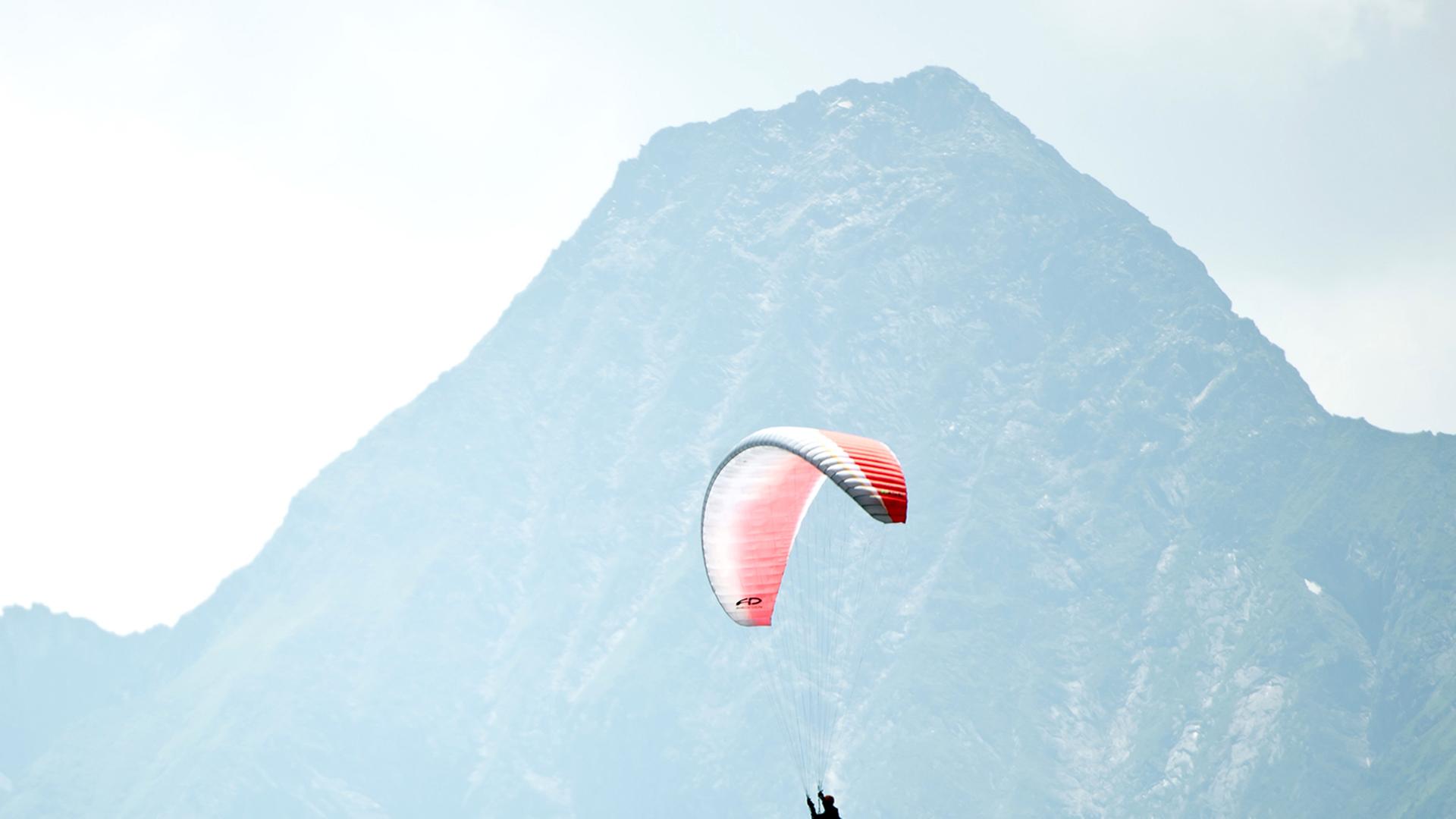 Ein Paraglider fliegt über Zell am Ziller in Österreich.