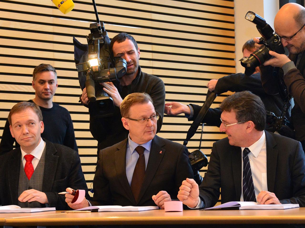 Matthias Hey (l-r, SPD), Bodo Ramelow (Die Linke) und Dieter Lauinger (Bündnis 90/Die Grünen) unterzeichnen am 04.12.2014 in Erfurt (Thüringen) den Koalitionsvertrag.