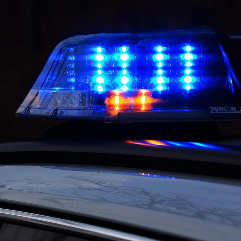 Ein Einsatzfahrzeug der Polizei in der Dunkelheit, mit Blaulicht