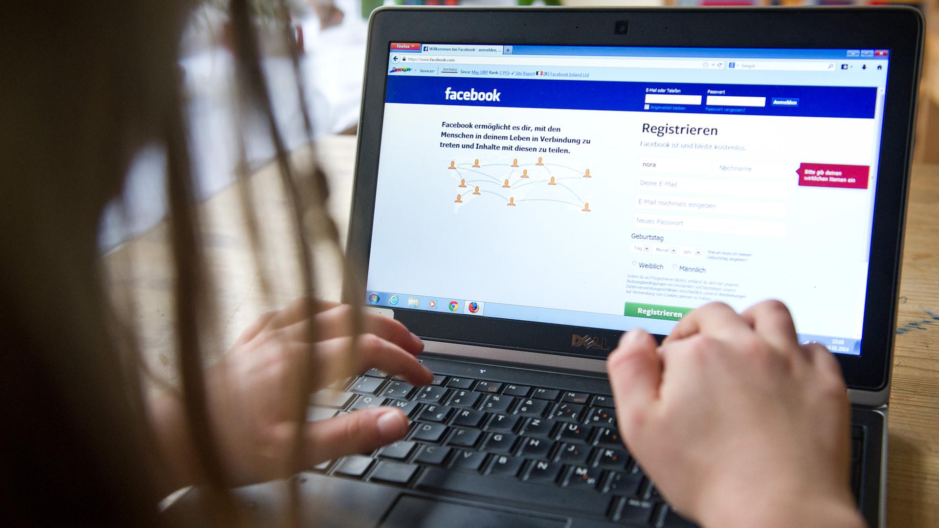 Ein Kind surft an einem Laptop auf der Seite des sozialen Netzwerks "Facebook".
