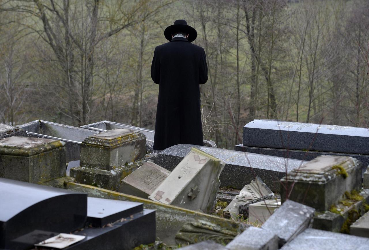 Ein Mann steht im zerstörten jüdischen Friedhof von Sarre-Union in Frankreich 
