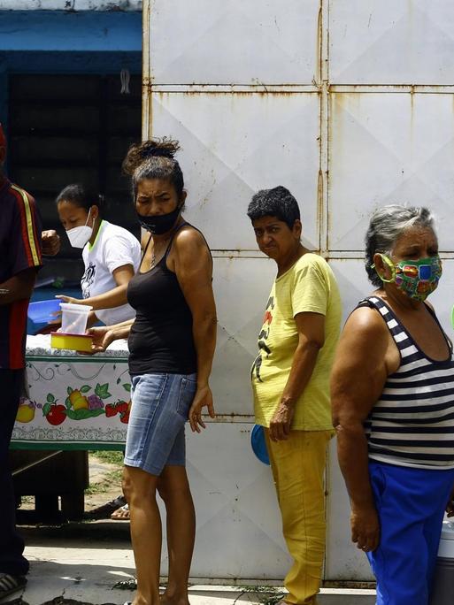 Menschen stehen Schlange für ein Essen: Nachbarn unterstützen bedürftige, ältere Menschen, aufgenommen am 17. Oktober 2020 in Valencia, Carabobo, Venezuela.