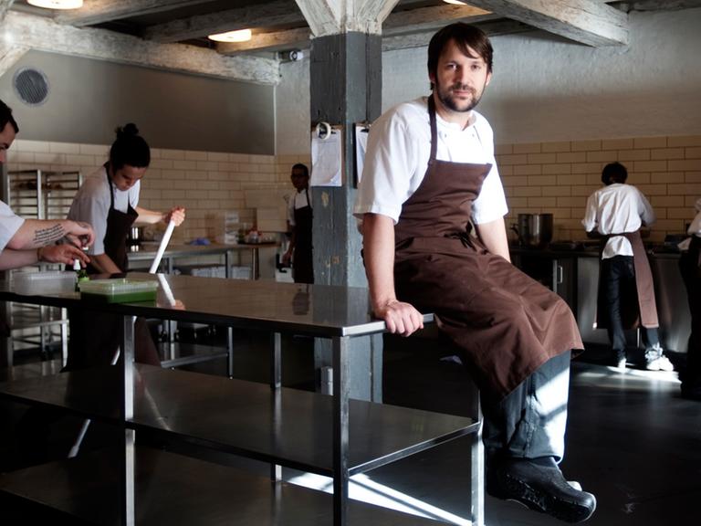 Chefkoch René Redzepi sitzt auf einem Servierwagen in der Küche seines Restaurants