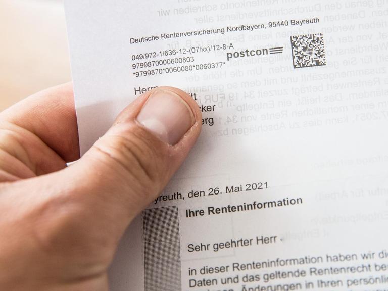 Eine Person hält einen Rentenbescheid der Deutschen Rentenversicherung in der Hand
