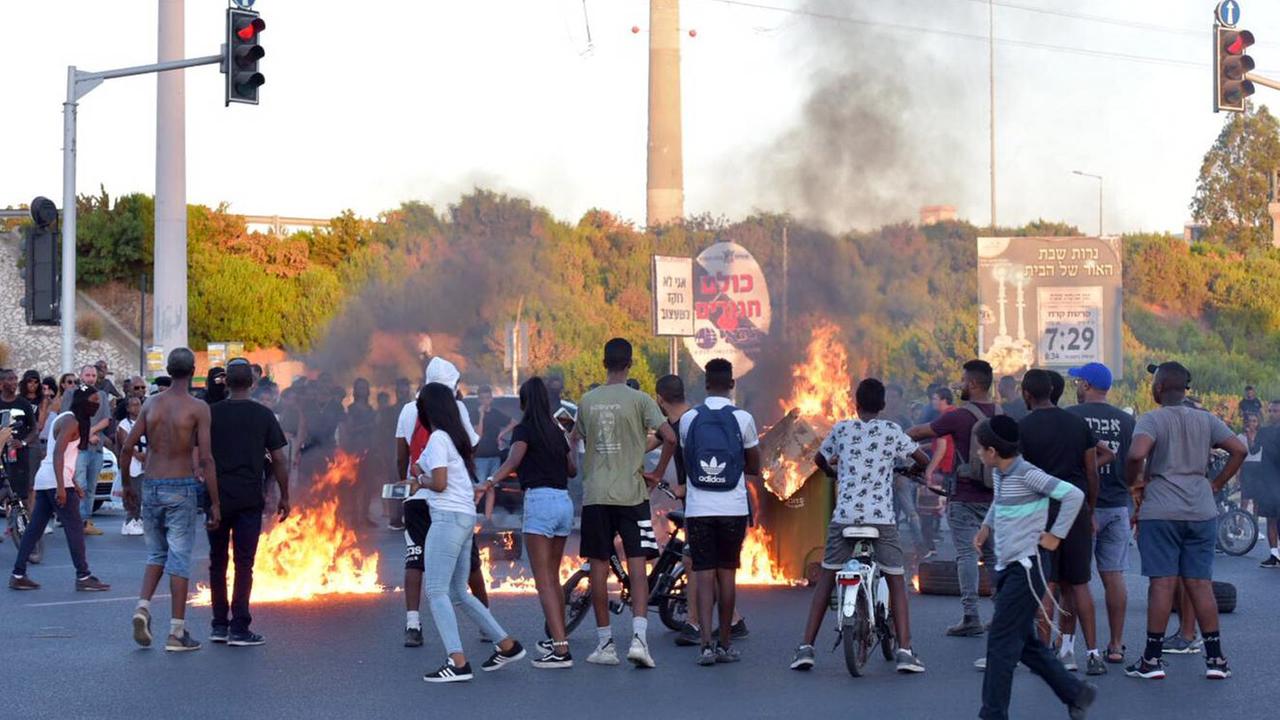 Tel Aviv: Demonstranten stehen auf einer Straße um ein Feuer herum.