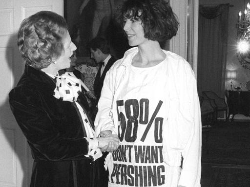 Die damalige britische Premierministerin Margaret Thatcher begrüßt am 17. März 1984 die Modedesignerin Katharine Hamnett, die ein T-Shirt als Protest gegen die nukleare Pershing-Rakete trägt.