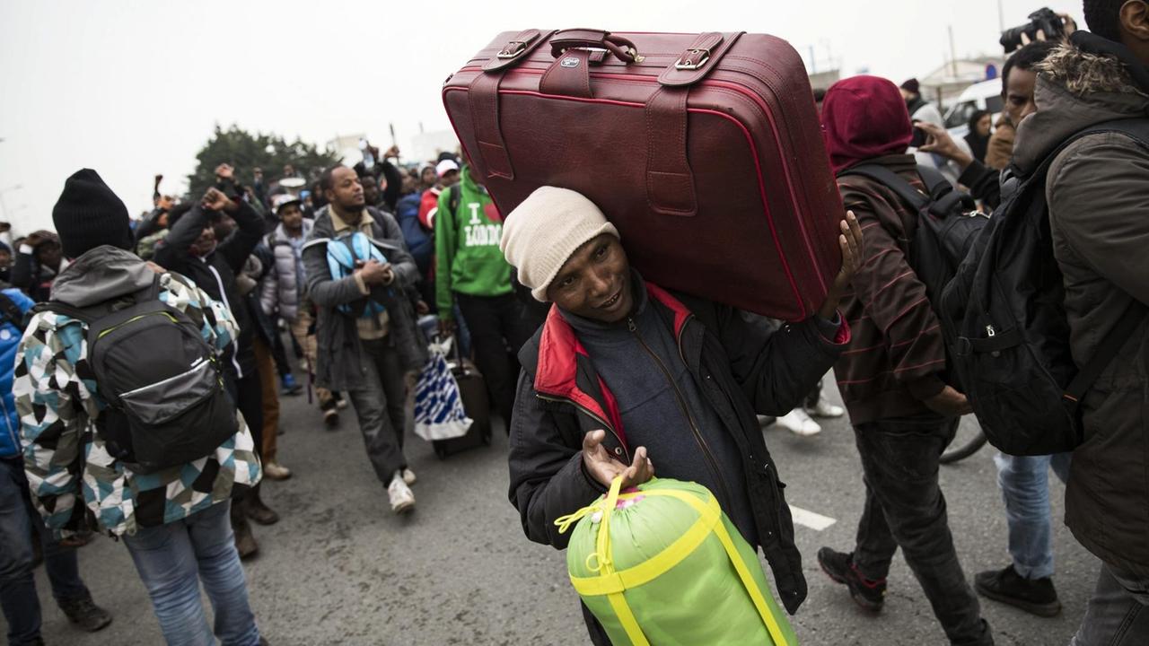Ein Flüchtling aus Äthiopien wird von der französischen Polizei aus dem Flüchtlingslager in Calais begleitet.