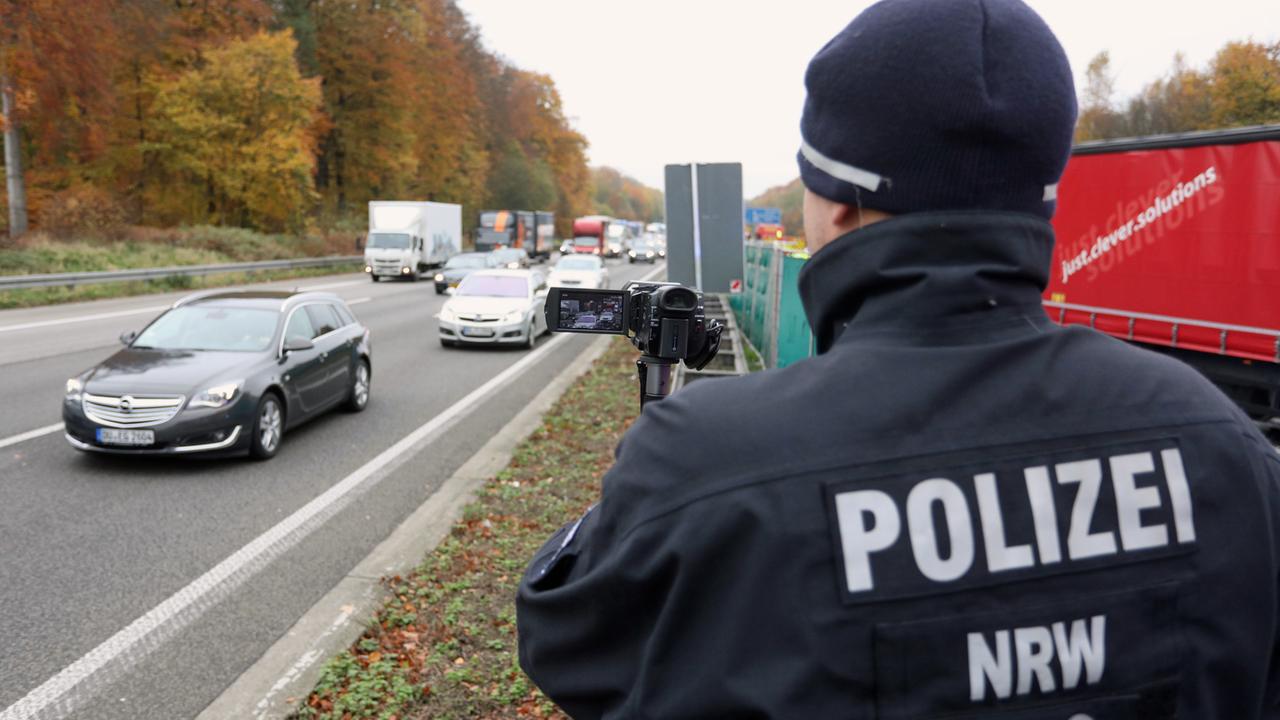 Ein Polizist filmt am 16.11.2017 in Ratingen (Nordrhein-Westfalen) auf der Autobahn A3 bei einem schweren Unfall auf der Gegenspur vorbeifahrende Autos.
