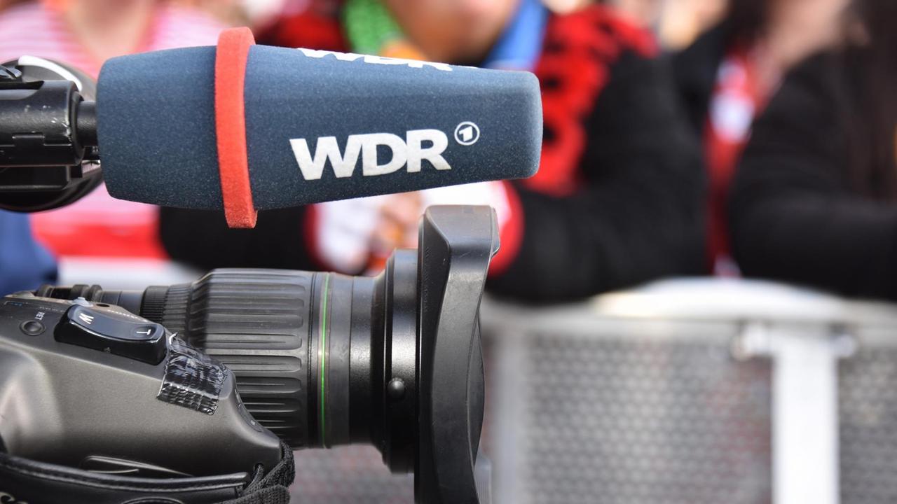 Mikrofon mit der Aufschrift WDR an einer Kamera