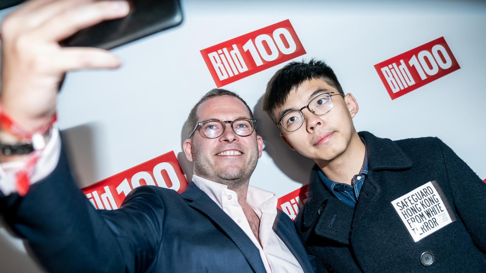 "Bild"-Chefredakteur Julian Reichelt macht ein Selfie mit Joshua Wong, Demokratie-Aktivist der Proteste in Hongkong, bei dessen Eintreffen zur Bild100-Party mit Persönlichkeiten aus Politik, Gesellschaft und Sport.